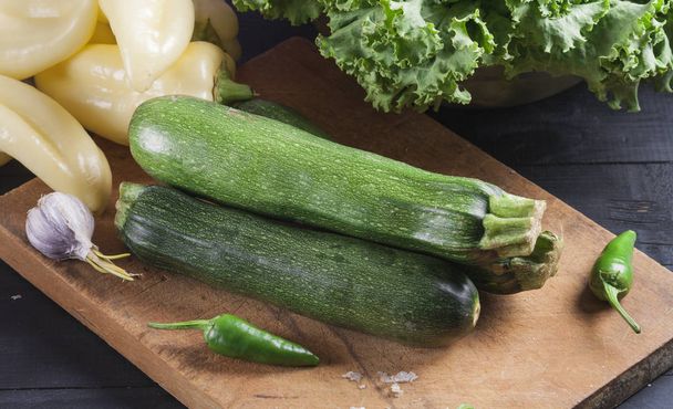 Zucchini. Fresh vegetables on a wooden board. Vegan food. - Fotoğraf, Görsel