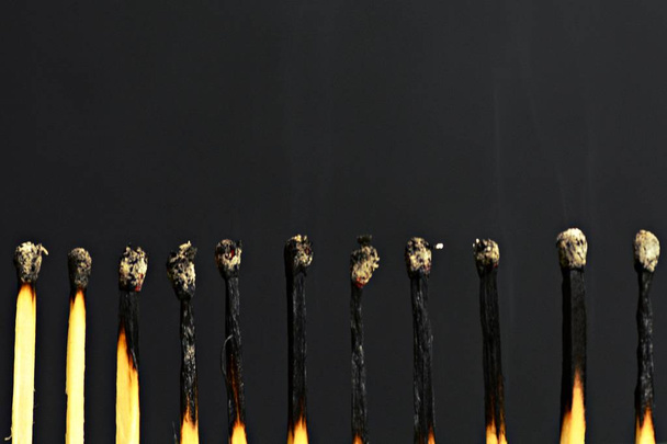burning Matches in a row in front of a black background - Photo, Image