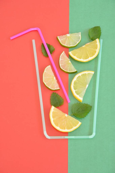 Creative layout strawberry lemonade ingredients - lemon, citrus, ice falling in glass made with cocktail straws on colorful background. Summer drinks. Minimal food concept. Selective focus. - Photo, Image