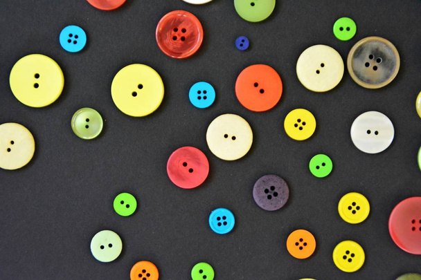 A large set of buttons in different colors and designs in front of one colored background  - Foto, Imagem