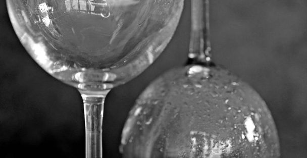 Gros plan sur deux verres à vin vides avec condensation sur le côté du verre sur un fond sombre
 - Photo, image