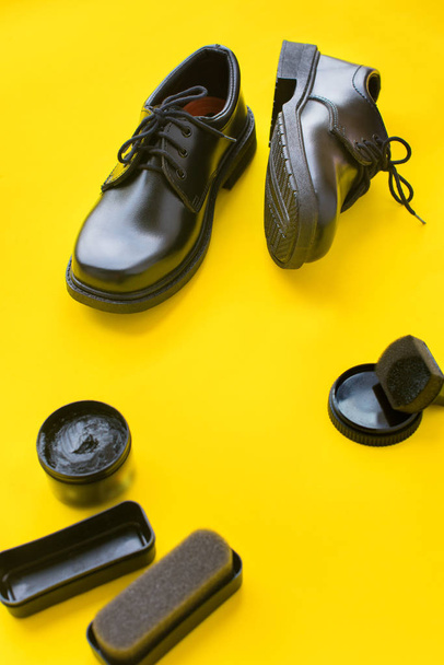 Black leather shoes yellow background top view - Φωτογραφία, εικόνα