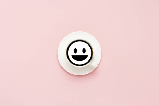 White cup on a saucer, black coffee, pink background. Sign face  - Foto, immagini