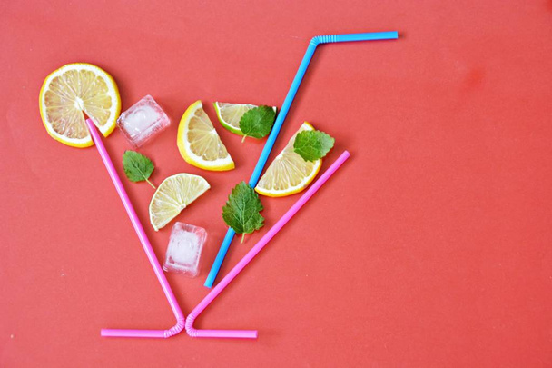 Concept for summer drink - Straws make up the glass in the lemons, limes, mint and ice floats against a colorful background - Abstract illustration of a summery refreshmentwith space for text  - Photo, Image