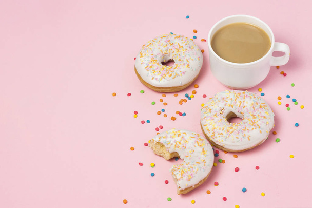 A cup of coffee with milk, Fresh tasty sweet donuts on a pink background. The concept of fast food, bakery, breakfast, sweets. Minimalism. Flat lay, top view, copy space - Photo, Image