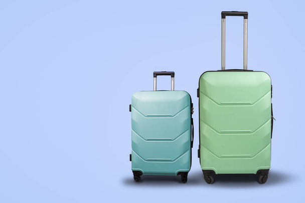Dva kufry na kolečkách na modrém pozadí. Koncepce cestování - Fotografie, Obrázek