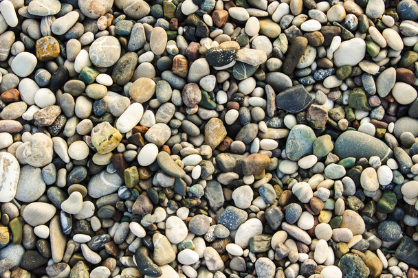 Strand stenen kiezels. De textuur van kleine stenen en zand. Can b - Foto, afbeelding