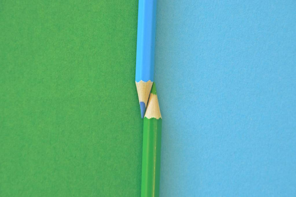 Два цветных карандаша разделяют картинку пополам двумя разными цветами
 - Фото, изображение
