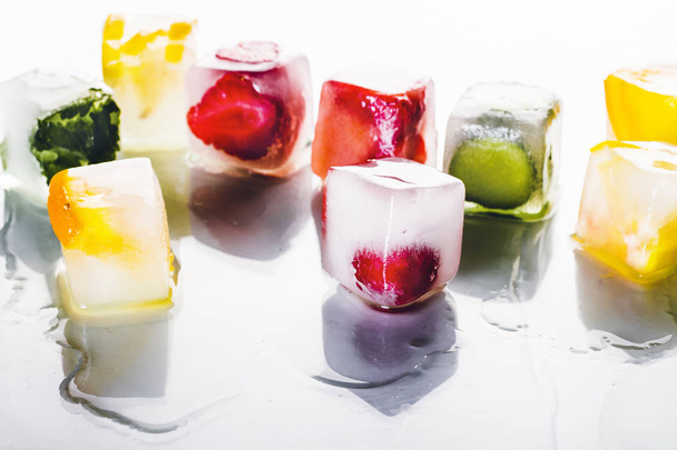 Parlak beyaz bir arka plan üzerinde meyve ile buz küpleri. Sıcak yaz, tatlı, dondurma kavramı. Düz döşeme, üst görünüm - Fotoğraf, Görsel