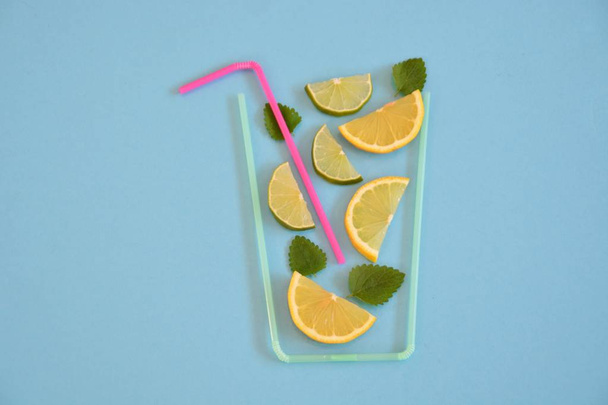 Творческая компоновка клубничного лимонада ингредиенты - лимон, цитрусовые, лед падает в стекло из соломы коктейля на красочном фоне. Летние напитки. Минимальная концепция питания. Селективный фокус
. - Фото, изображение