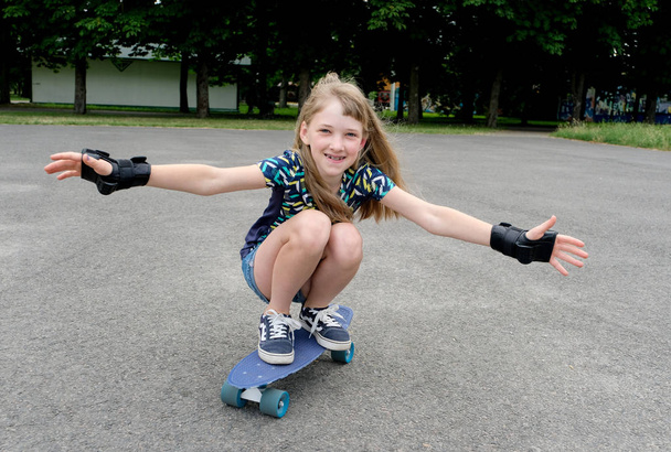 Happy girl rides on a skateboard  - Фото, изображение