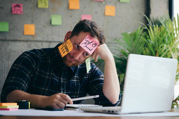 Hombre estresado con mensaje en notas adhesivas sobre su cara en offic
 - Foto, imagen