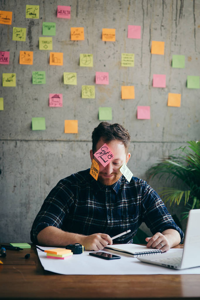 Stressed man with message on sticky notes over his face in offic - Foto, Imagem
