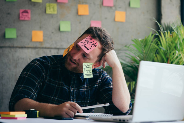 Stressed man with message on sticky notes over his face in offic - Foto, Bild