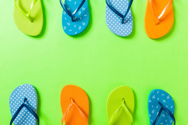 una gran cantidad de sandalias de color chancla, vacaciones de verano sobre fondo de color, vista superior del espacio de copia
 - Foto, imagen