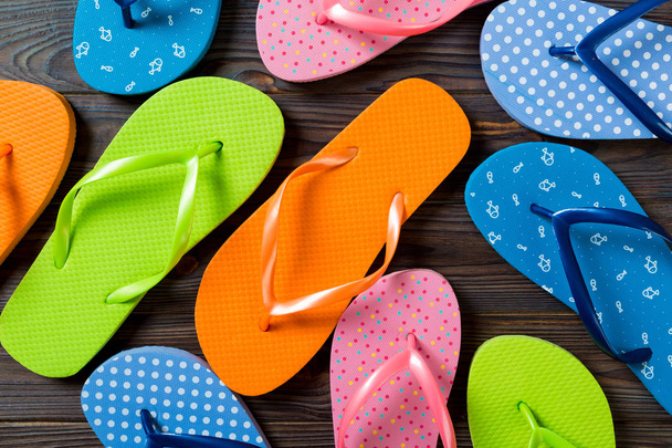 flip flop renkli sandalet bir sürü, ahşap arka plan üzerinde yaz tatili, kopya alanı üst görünümü - Fotoğraf, Görsel