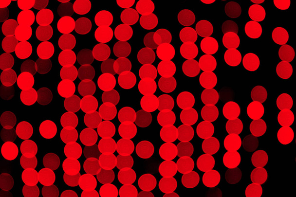 Nieskoncentrowany abstrakcyjny czerwony bokeh na czarnym tle. rozmazany i rozmyty wiele okrągłych świateł - Zdjęcie, obraz