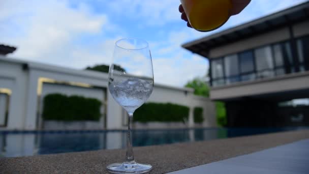 Gezonde sinaasappelsap gieten tot versheid frisdrank glas lekker en zoet buiten bij het zwembad. Verse sinaasappelboom Gaard - Video