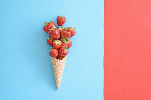 cone de sorvete com morangos em um fundo colorido
 - Foto, Imagem