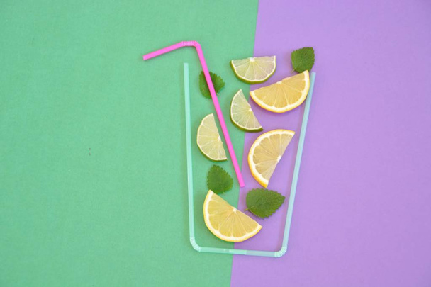 Творческая компоновка клубничного лимонада ингредиенты - лимон, цитрусовые, лед падает в стекло из соломы коктейля на красочном фоне. Летние напитки. Минимальная концепция питания. Селективный фокус
. - Фото, изображение