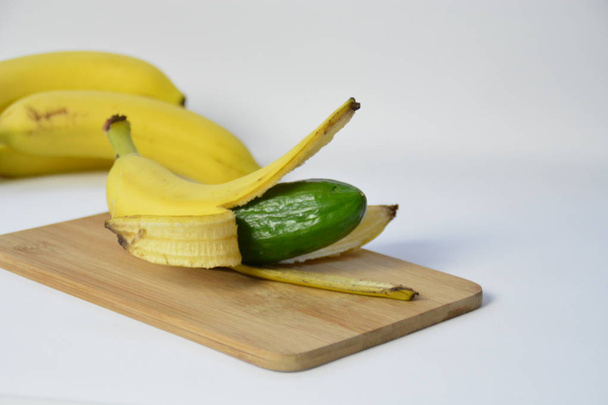 A cucumber in the peel of a banana - 写真・画像