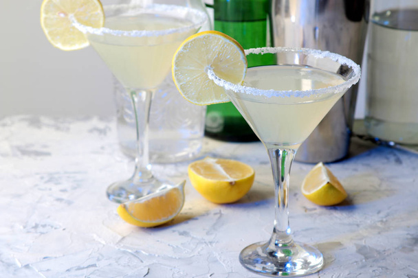 Коктейль Маргарита, алкогольный напиток, коктейль Маргарита с лимоном и мятой на светлом столе. бар. принадлежности и аксессуары для баров
 - Фото, изображение