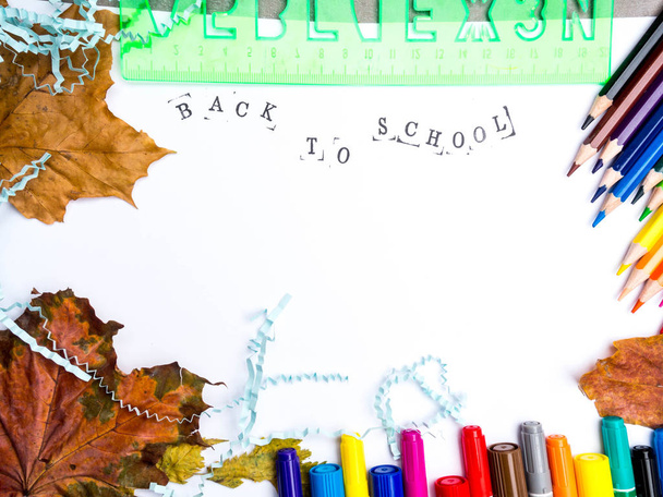 Orazítkovaný nápis zpět do školy se značkami, tužkami, modrým literálem, zeleným panovníkem a podzimním listím, koncept vzdělávací koncepce, září - Fotografie, Obrázek