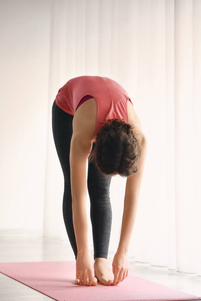 Sportos fiatal nő jóga beltéri gyakorlás - Fotó, kép
