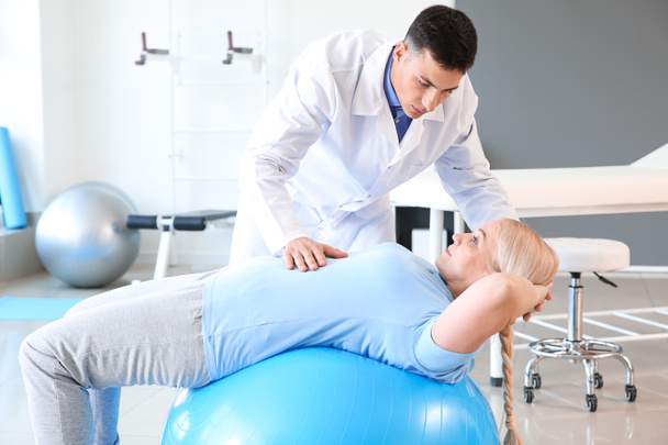 Physiothérapeute travaillant avec un patient mature dans un centre de réadaptation
 - Photo, image