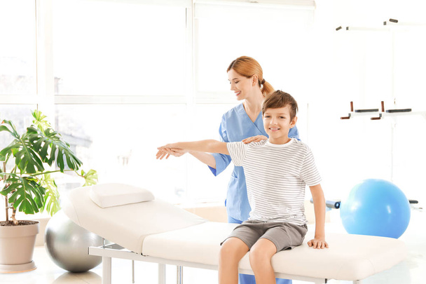 Physiotherapist working with little boy in rehabilitation center - Foto, Bild