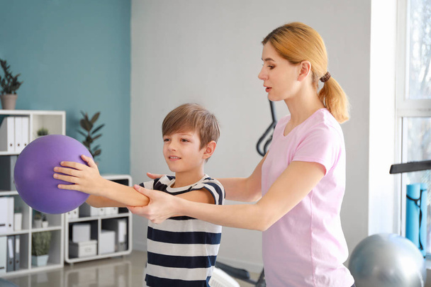 Physiotherapeutin arbeitet mit kleinem Jungen im Reha-Zentrum - Foto, Bild