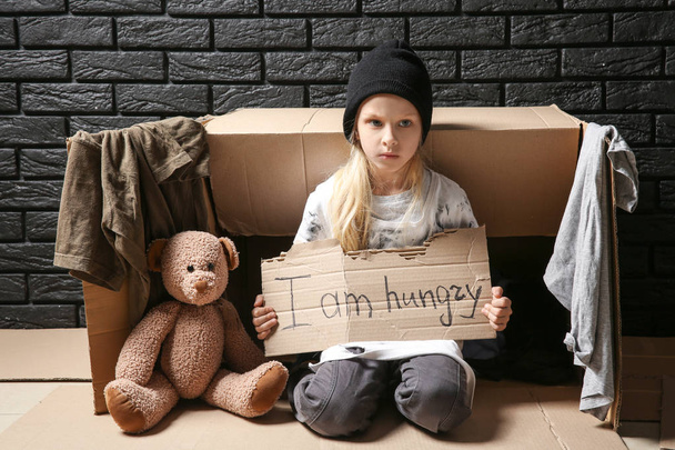 Ένα άστεγο κοριτσάκι που παρακαλάει για φαγητό σε εσωτερικούς χώρους - Φωτογραφία, εικόνα