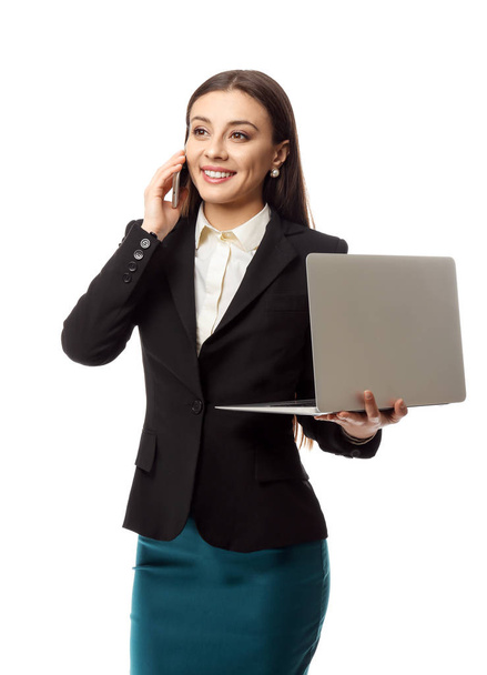 Stylish businesswoman with laptop talking by phone on white background - Fotoğraf, Görsel