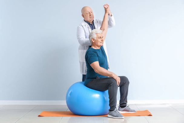 Senior physiotherapist working with mature man in clinic - Photo, Image