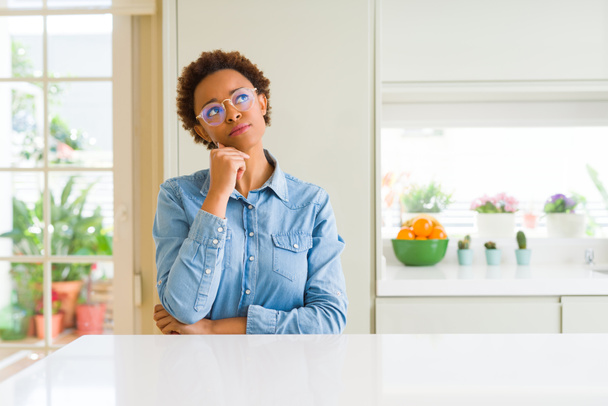 Young beautiful african american woman wearing glasses with hand on chin thinking about question, pensive expression. Smiling with thoughtful face. Doubt concept. - Foto, Bild