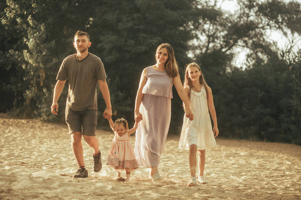 Μια ευτυχισμένη οικογένεια περπατάει μέσα από το δάσος. - Φωτογραφία, εικόνα