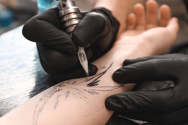 Professional artist making tattoo in salon, closeup - Photo, Image
