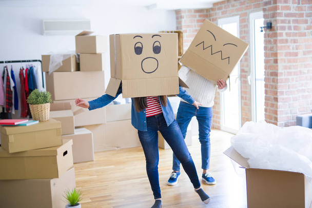 Crazy couple wearing boxes with funny faces over head, having fu - Photo, Image