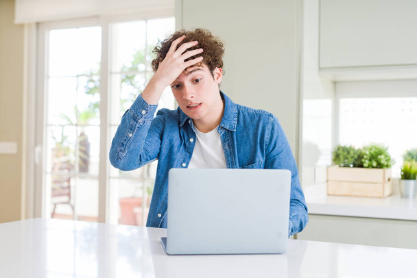 Mladý muž, který používal počítačový notebook, byl ve stresu s rukou na hlavě, šokován hanbou a překvapením, rozzlobený a frustrovaný. Strach a rozčílený omyl. - Fotografie, Obrázek