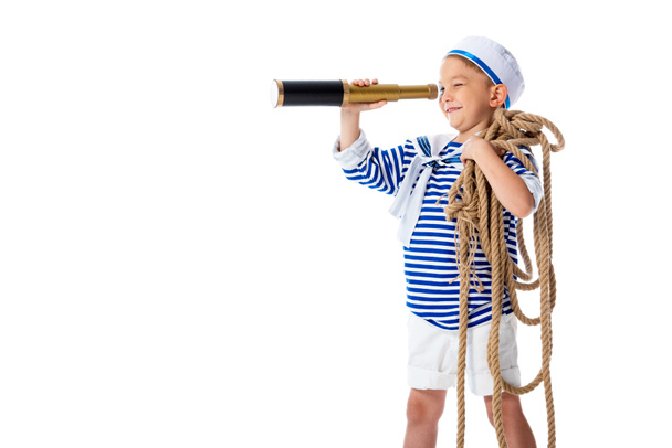 smiling preschooler child in sailor costume looking in spyglass and holding rope isolated on white - Fotografie, Obrázek