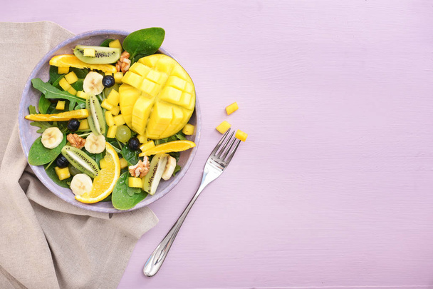 Plate ízletes mangó saláta színes háttér - Fotó, kép