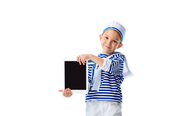 vue de face de l'enfant préscolaire souriant en costume marin tenant tablette numérique avec écran blanc isolé sur blanc
 - Photo, image