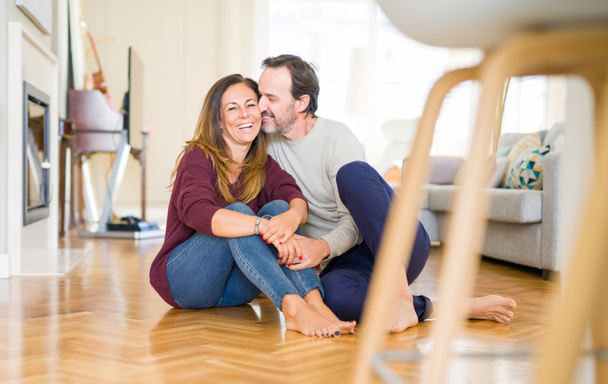 Beautiful romantic couple sitting together on the floor at home - Foto, immagini