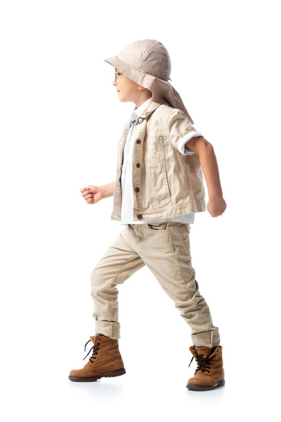 side view of explorer child in hat standing on white - Фото, изображение