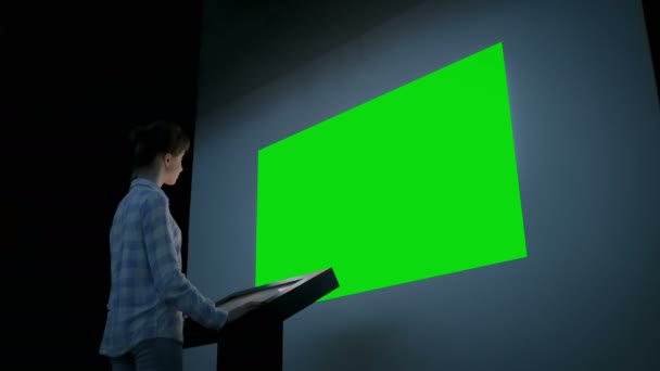 Женщина с помощью киоска и глядя на большой пустой зеленый экран - концепция хрома ключ - Кадры, видео