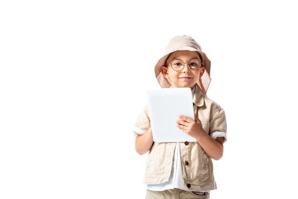 vista frontale del bambino esploratore allegro in occhiali e cappello tenendo tablet digitale isolato su bianco
 - Foto, immagini