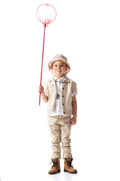 full length view of smiling explorer boy in glasses holding butterfly net isolated on white - Photo, Image