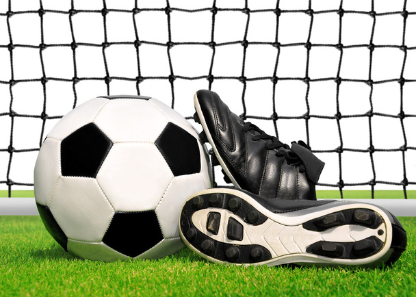 サッカー ボールや草の中の靴 - 写真・画像
