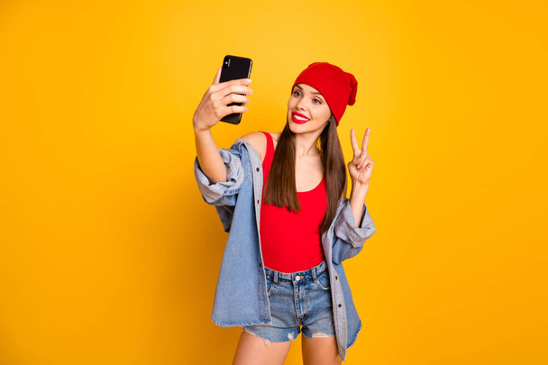 Portrait of charming trendy stylish youth make photo travel trip have weekend make v-signs isolated over yellow background - 写真・画像