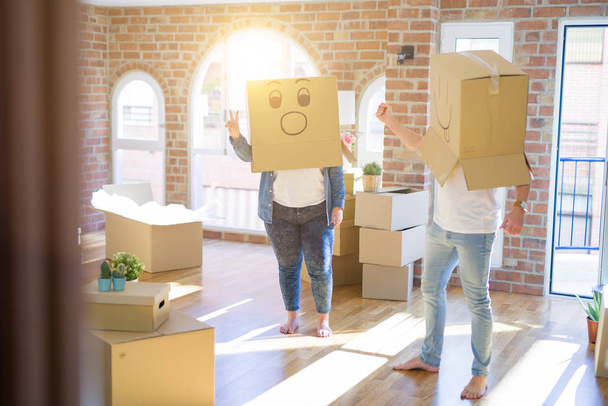 Pareja loca usando cajas de cartón con caras divertidas de emoji
 - Foto, Imagen